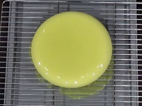 L'entremets posé sur la grille, elle-même placée sur une plaque creuse, est nappé de glaçage vert