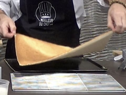 Le biscuit fromage blanc est soulevé pour être posé sur une grille