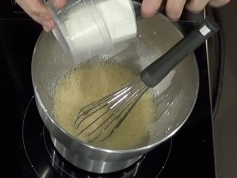 Ajout du sirop de glucose dans la cuve du batteur, sur la préparation aux oeufs et au fromage blanc