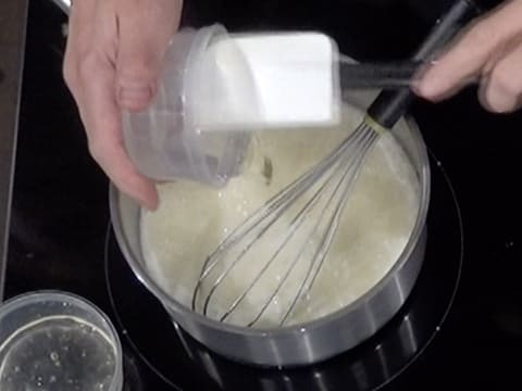 Ajout du sirop de glucose dans la casserole sur la crème et le sucre en ébullition