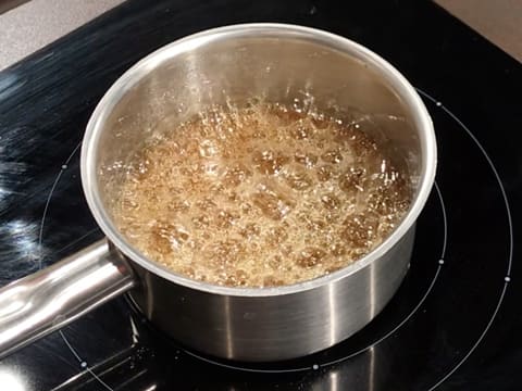 Obtention d'un caramel bien doré et en ébullition dans la casserole sur la plaque de cuisson
