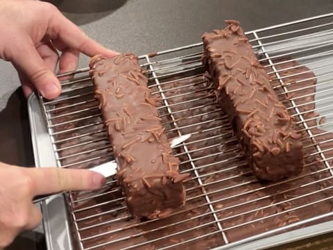 Un gâteau est décollé de la grille avec la lame d'un couteau