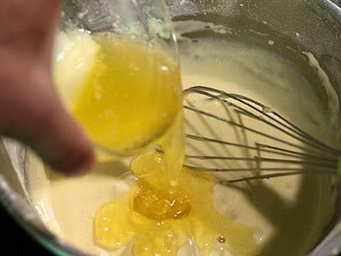 Ajout du beurre fondu sur la préparation dans le cul de poule