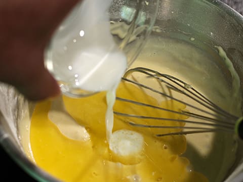 Ajout du lait sur le beurre fondu et sur la préparation dans le cul de poule