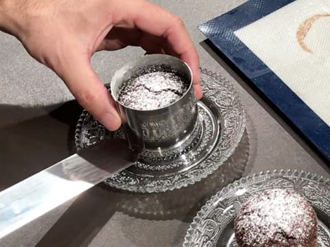 À l'aide d'une spatule métallique coudée, un second mi-cuit au chocolat est déposé sur son plat de présentation