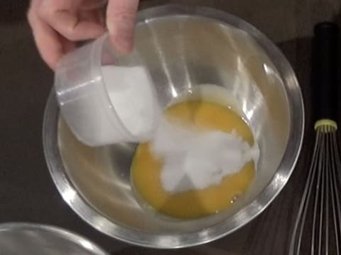 Ajout du sucre en poudre sur les jaunes d'oeufs, dans le cul de poule