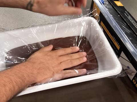 La ganache au chocolat dans le bac alimentaire, est filmée au contact