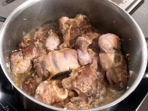 La viande, l'oignon et les carottes sont en train de cuire dans le faitout