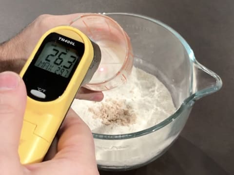 À l'aide d'un thermomètre à visée laser, prise de la température du lait qui se trouve dans le verre doseur gradué, et qui titre 26,3°C