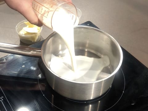 Le lait est versé dans une casserole qui est placée sur une plaque de cuisson