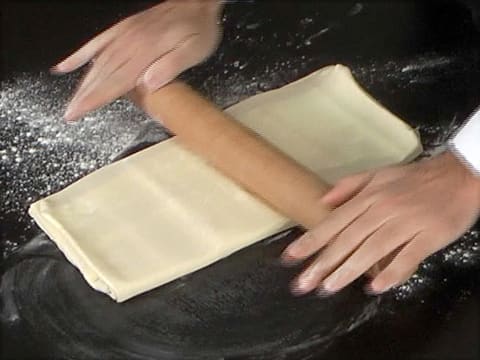 La pâte est abaissée sur la longueur avec le rouleau à pâtisserie sur le plan de travail fariné