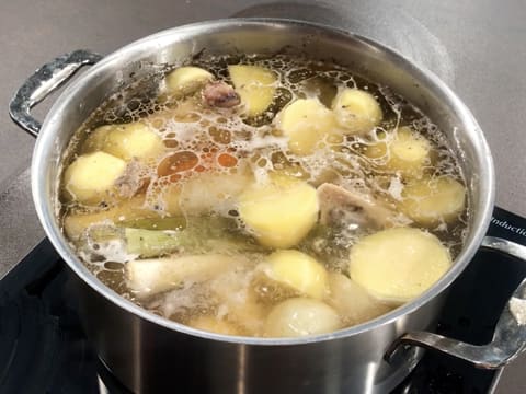 Le pot au feu est en train de cuire dans l'eau frémissante dans le grand faitout