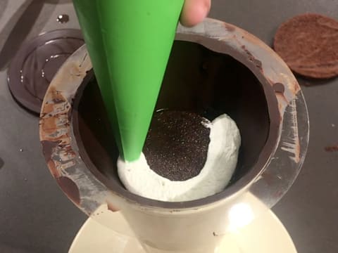 Un cordon de Chantilly mascarpone vanillée est pochée en spirale sur le biscuit chocolat, dans le cône en chocolat