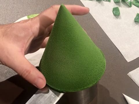 Le sapin en chocolat vert est déplacé à l'aide d'une spatule coudée