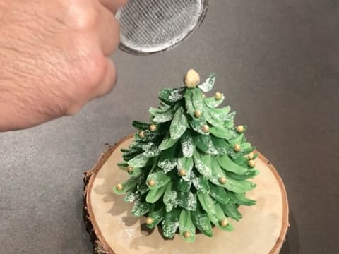 Du sucre Codineige est saupoudré sur le sapin en chocolat vert