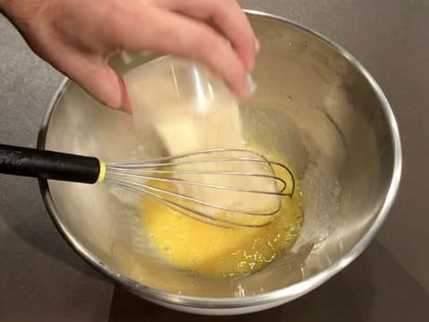 Ajout de la poudre d'amandes dans la préparation à base d'œufs et de sucre en poudre