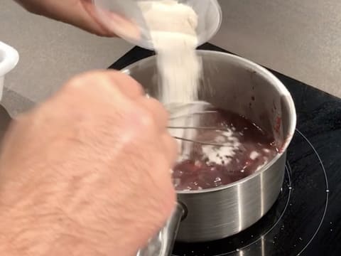 Le mélange sucre en poudre et pectine NH nappage est versé dans la casserole contenant la purée de griotte