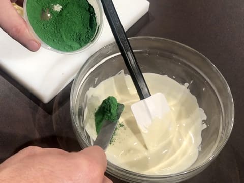 Ajout de colorant vert en poudre dans le bol de chocolat blanc fondu