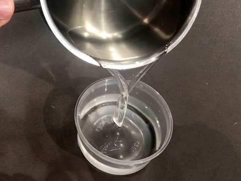 Un peu de sirop de punchage est versé dans un petit récipient