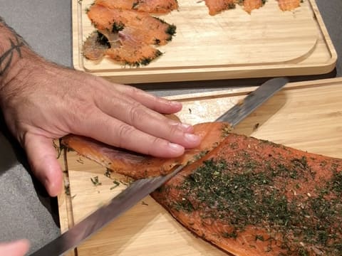 Une Planche De Bois Avec Un Morceau De Pain Avec Du Saumon Fumé Dessus Et  Un Couteau à Côté