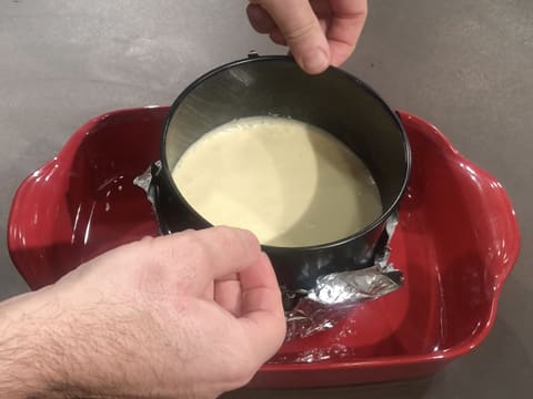 Le moule à charnière qui contient l'appareil au fromage blanc, est placé dans un plat à gratin