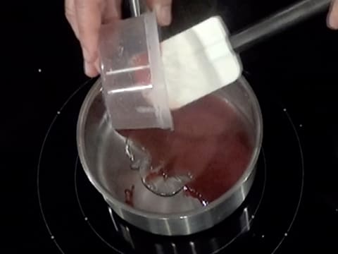 Le mélange masse de gélatine fondue et purée de fruits rouges est versé dans une casserole contenant le sirop de glucose