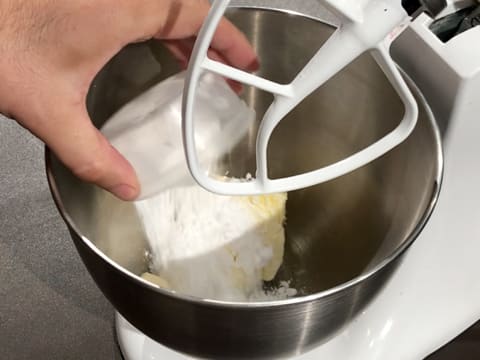 Ajout du sucre glace dans la cuve du batteur, sur le beurre pommade