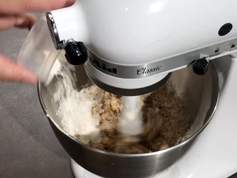 Ajout de la farine sur la préparation crémeuse dans la cuve du batteur électrique