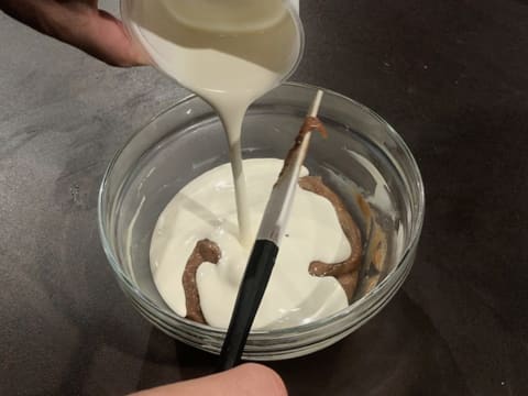 Ajout de la crème fleurette dans la crème au chocolat blanc et au praliné noix de pécan dans le saladier en verre