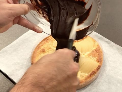 La ganache au chocolat est versée sur la tarte aux poires