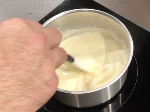 La crème au chocolat blanc est cuite à la nappe à l'aide de la spatule maryse dans une casserole