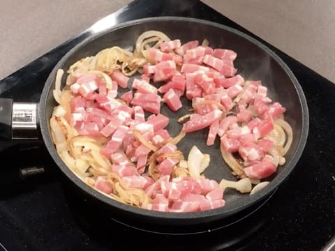 Ajout des lardons sur les oignons dorés dans la poêle qui est placée sur la plaque de cuisson