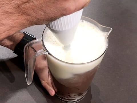 Mix the milk preparation and chocolate pistoles with a hand blender in the jug