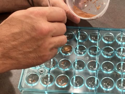 Apply bronze colouring in the cavities of a half sphere mould