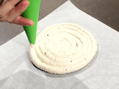 Pipe the preparation into a spiral inside the circle drawn on the greaseproof paper