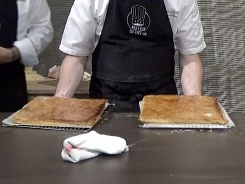 Two cooked puff pastry rectangles are on the kitchen workbench