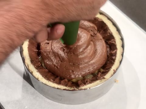 The chocolate mousse is piped over the pears