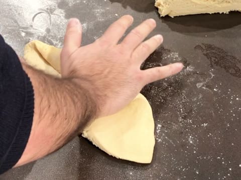 Flatten a brioche ball with your hand on a floured surface