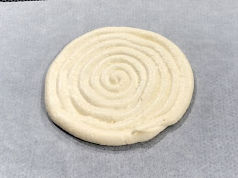 The lady finger disc is piped on the baking parchment